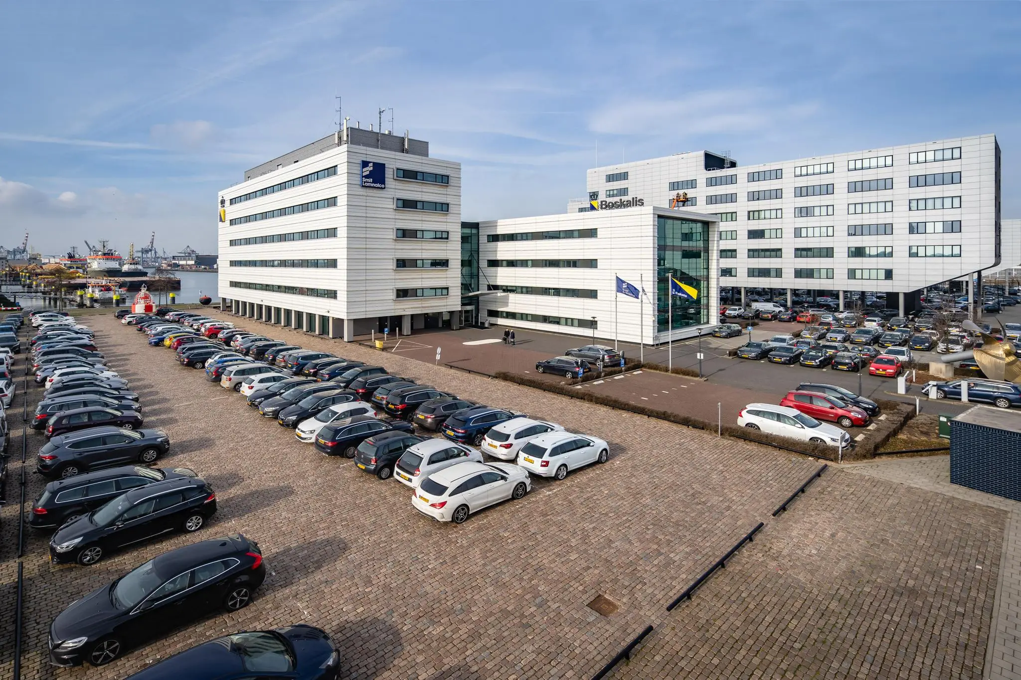 Kantoorgebouwen van Post Terminal en Boskalis aan de Waalhaven Oostzijde met een vol parkeerterrein op de voorgrond.